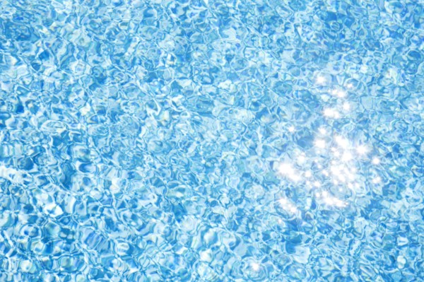 Sparkling reflections of sunlight on pool water surface