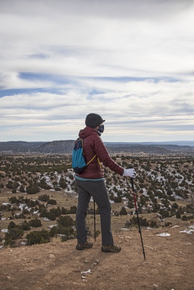 Senior woman wearing face mask hiking in Galisteo Basin Preserve