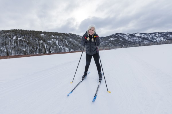 Portrait of senior woman cross - country skiing on groomed trails