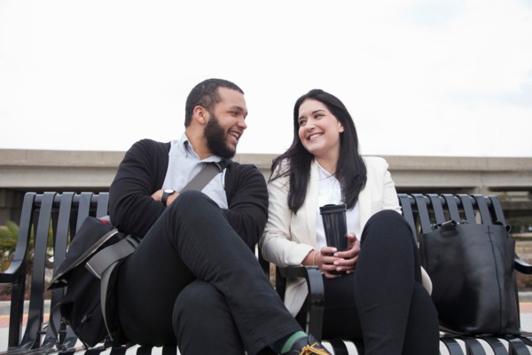 Young couple sitting on bench on platform