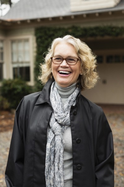 Portrait of contented senior woman outside house