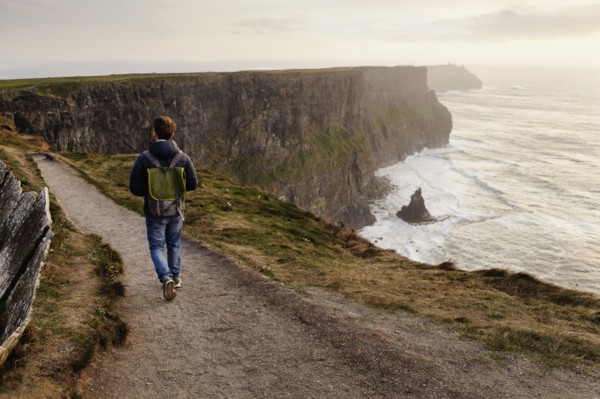 Mid adult man walking on The Cliffs of Moher