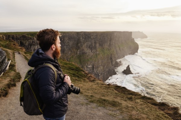 Mid adult man on The Cliffs of Moher with camera