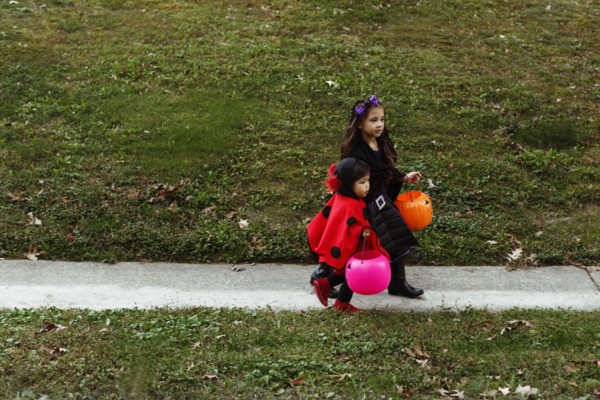 Two girls in fancy dress costumes walking down path