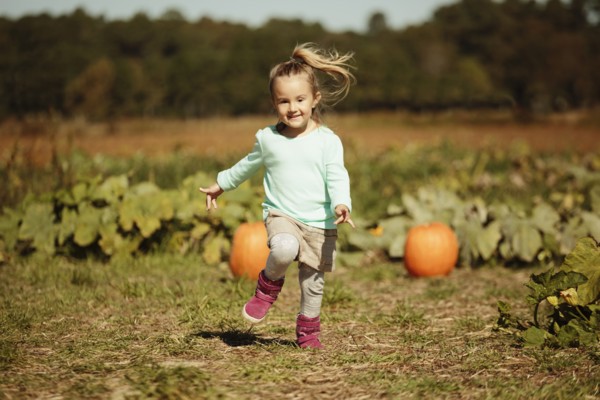 Girl running in pumpkin field