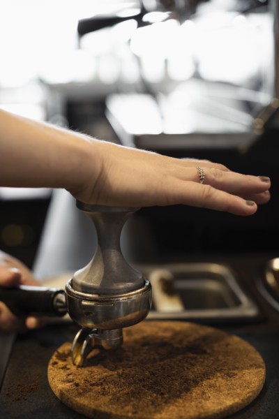 Coffee shop barista removing coffee grounds