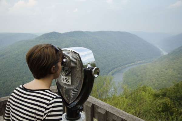 Mid adult woman looking through coin operated binoculars