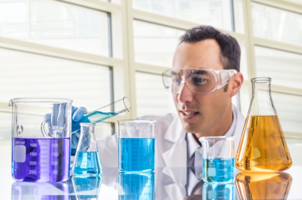 Scientist pouring blue liquid in laboratory