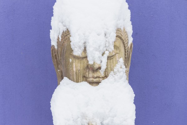 Snow covering stone Buddha statue
