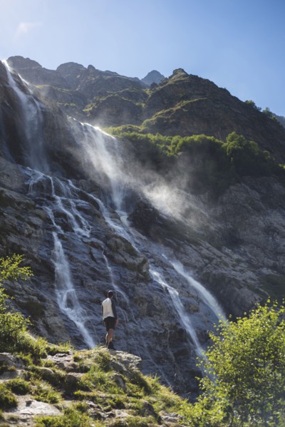 Man standing near Sofiyskiye Vodopady waterfall in Caucasus Mountains