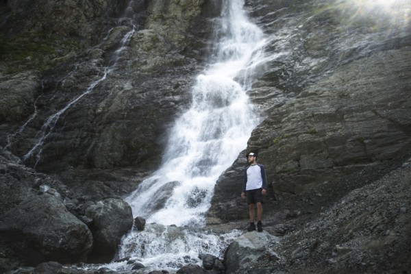 Man standing near Sofiyskiye Vodopady waterfall in Caucasus Mountains