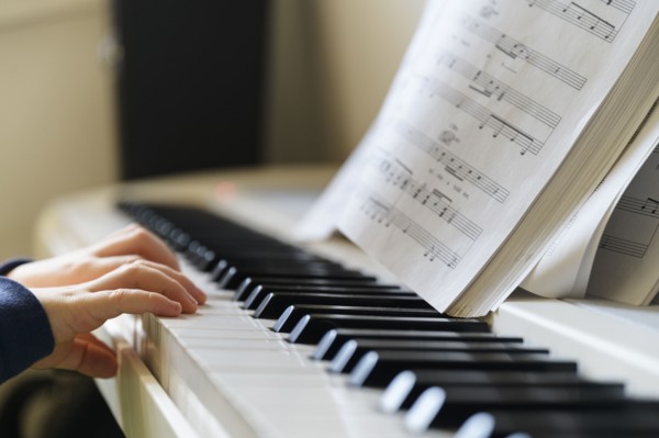 Hands of boy (6-7) playing piano