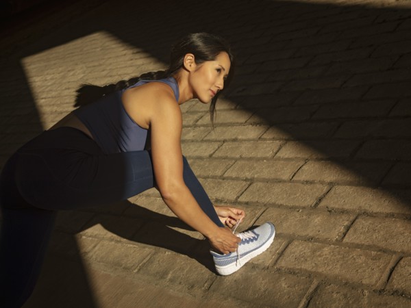 Athletic woman tying sport shoe outdoors