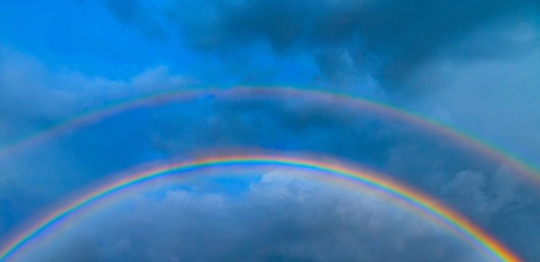 Double rainbow against stormy sky