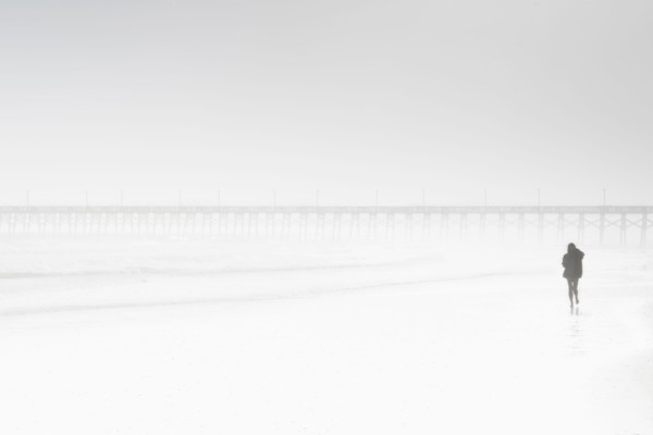 Usa, North Carolina, Surf City, Woman walking on misty beach