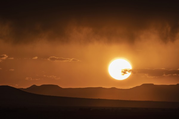 Usa, New Mexico, Santa Fe, El Dorado, Sun setting over landscape with clouds