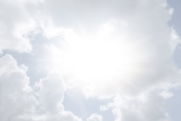 Sun shining through white clouds