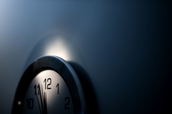 Close-up of wall clock with hands approaching midnight