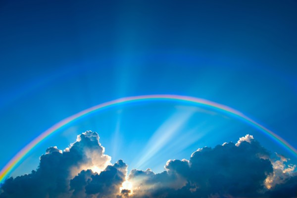 Double rainbow and clouds on sky at sunset