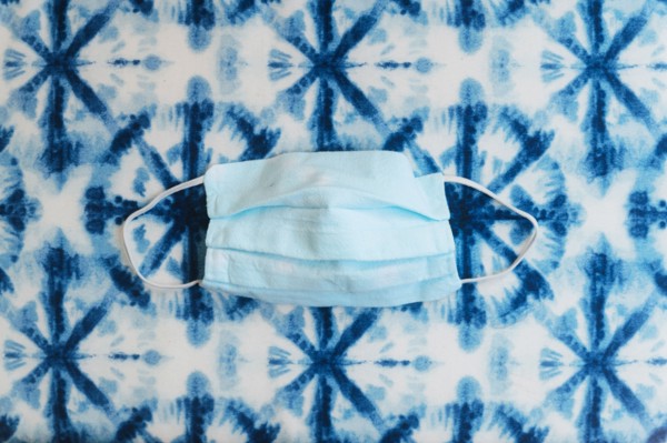 Face mask on patterned blue background
