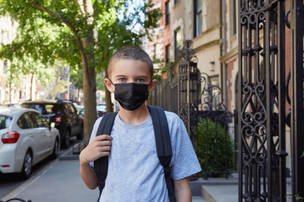 Portrait of Boy in face mask standing on sidewalk