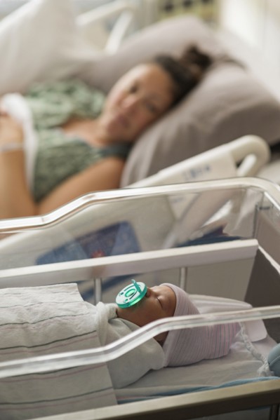 Mother lying with newborn baby girl