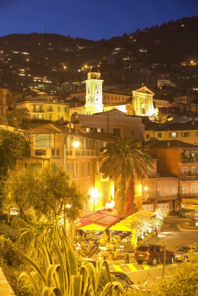 Palm trees and illuminated old town buildings