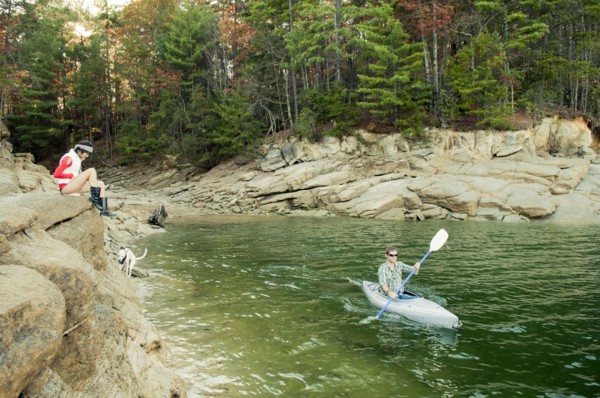 Woman watching boyfriend in kayak in lake