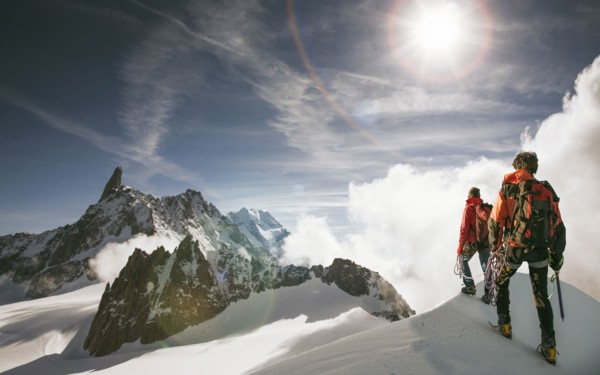 Caucasian hikers standing on snowy mountain top