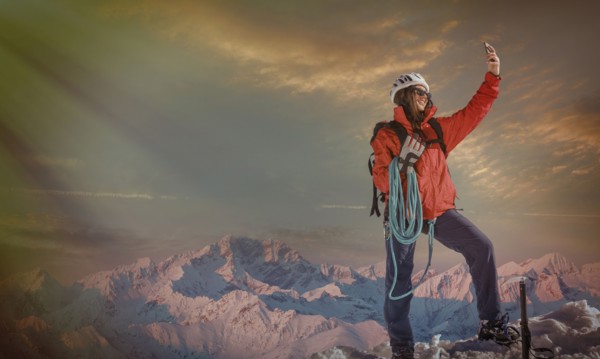 Caucasian hiker taking selfie on mountaintop