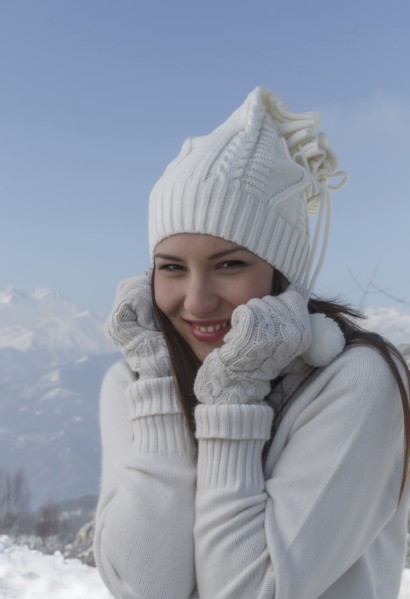 Caucasian woman wearing hat and gloves in snow
