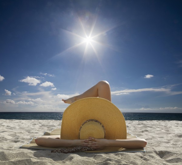 Caucasian woman relaxing on beach under blue sky