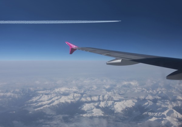 Airplanes flying in blue sky over Swiss Alps