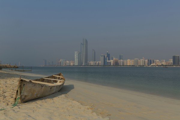 Canoe on beach near city skyline