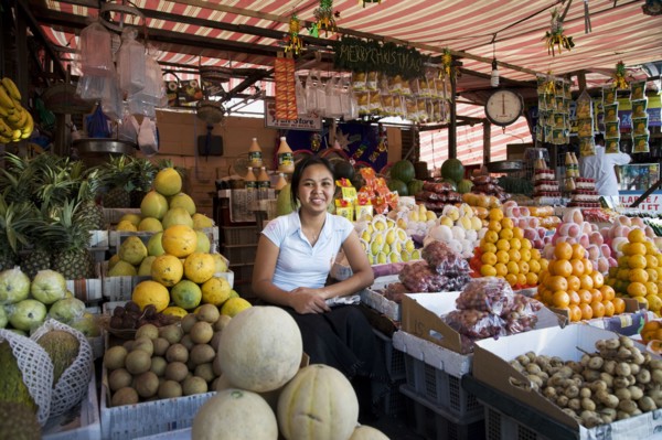 Asian vendor smiling at market