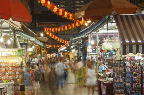 Blurred view of people shopping in outdoor market at night