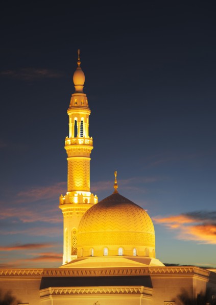 Illuminated pillar and dome under sunset sky