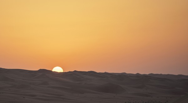 Sunrise over sand dunes in desert landscape