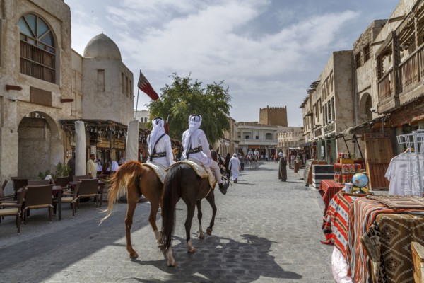 Men riding horses on Doha street