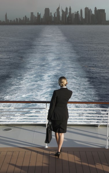 Caucasian businesswoman on boat leaving city