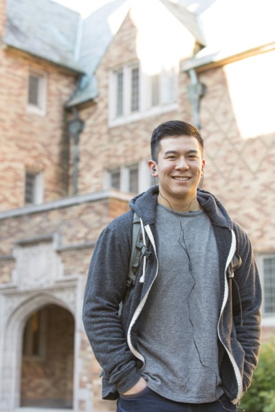 Mixed race college student listening to music on headphones