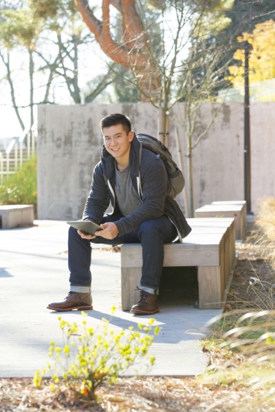 Mixed race college student using digital tablet on campus