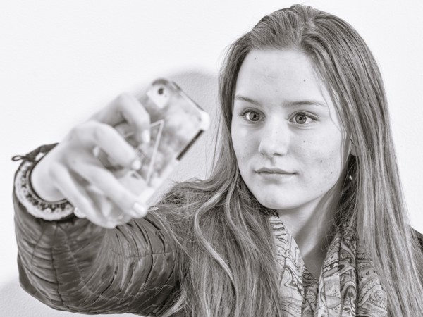 Caucasian teenage girl taking picture with cell phone