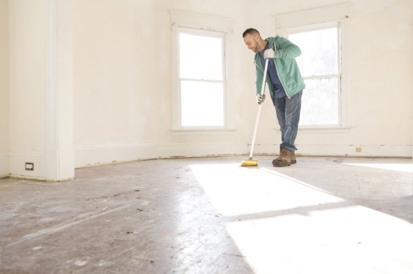 Mixed race man sweeping floor of new home