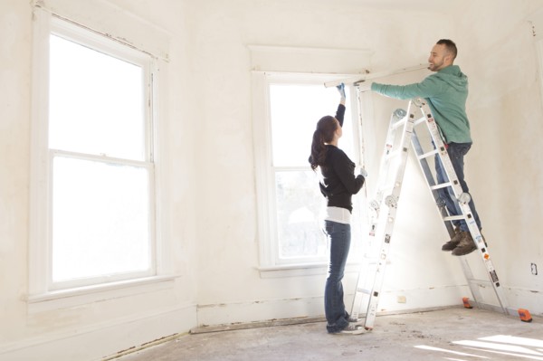 Mixed race couple installing shade in new home