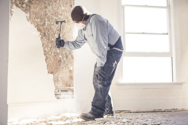 Hispanic construction worker hammering wall