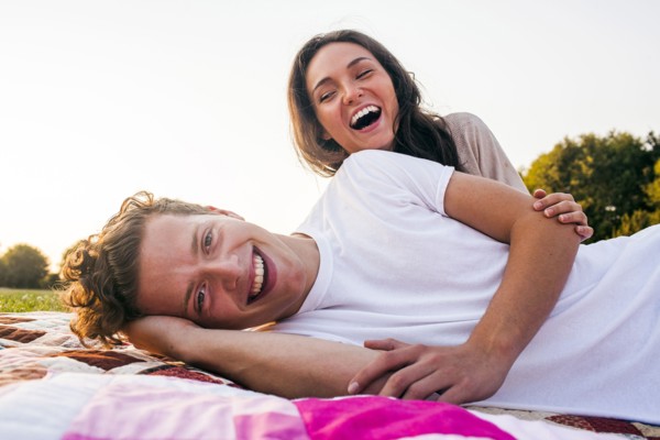 Caucasian couple relaxing on blankets in park