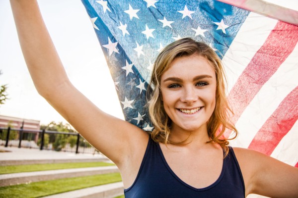 Caucasian teenage girl holding American flag