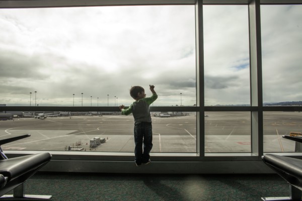 Mixed race boy looking out airport window