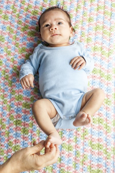 Mother tickling foot of baby boy